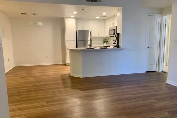 Bright apartment living room showing open kitchen access