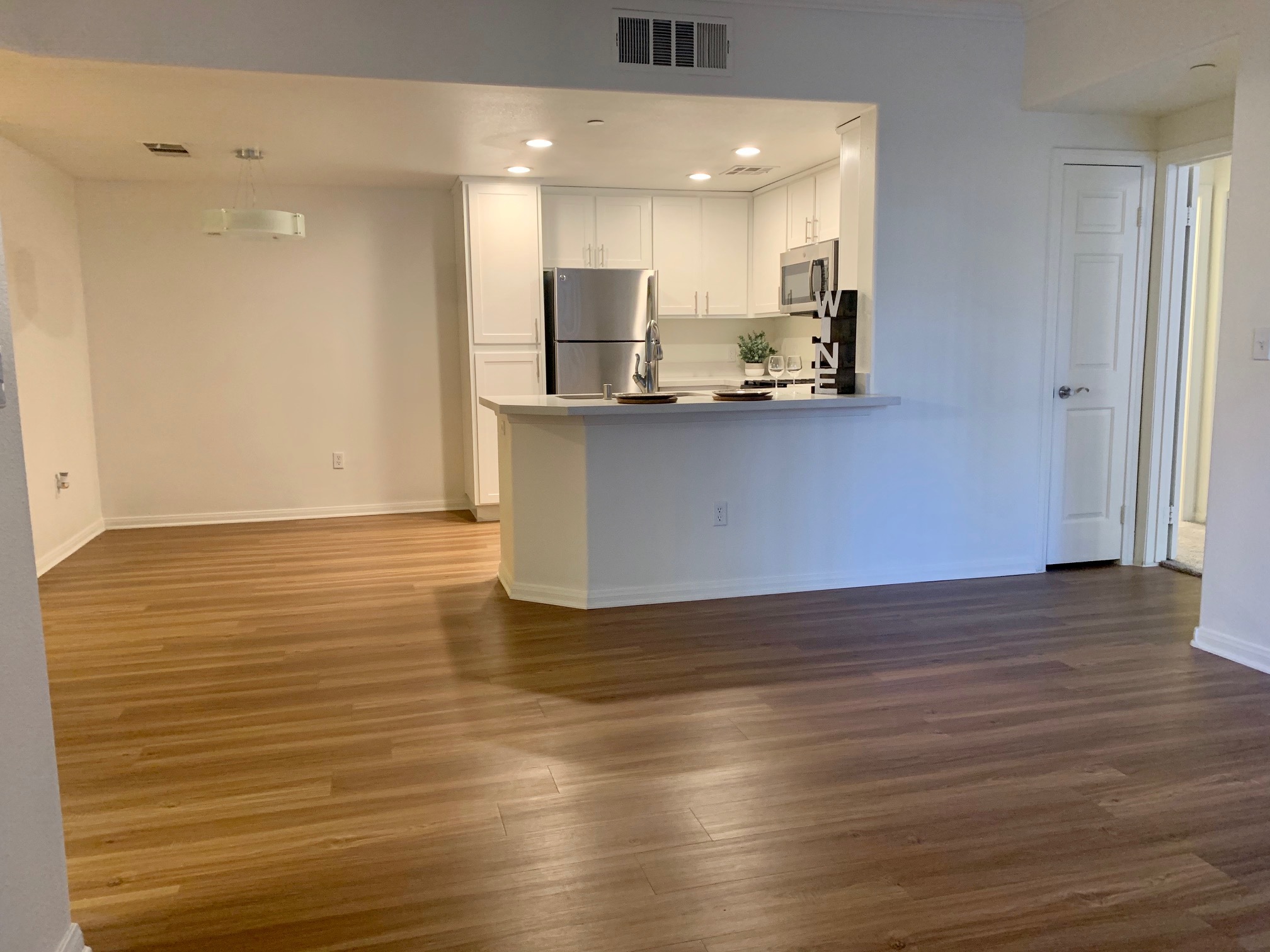 Bright apartment living room showing open kitchen access
