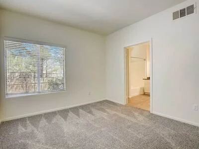 Bedroom with neutral carpet and large window
