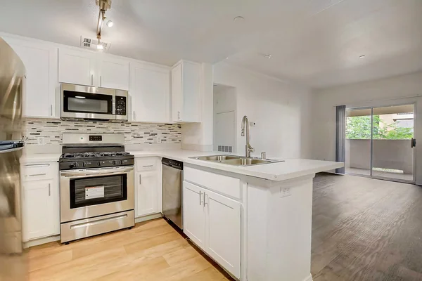 Ritiro Apartments kitchen with stainless steel appliances, dining area, and back patio view in Peccole Ranch Las Vegas